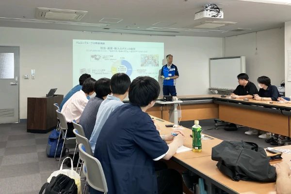 会議室で発表者の方を見ている。